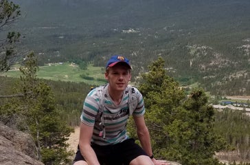Mariusz Starzec enjoying a trail with a backdrop of Mount Meeker and Longs Peak.